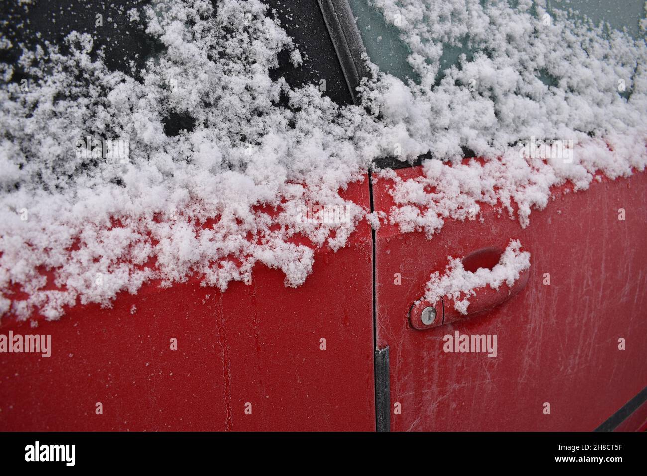 Neige sur une poignée de porte de voiture. Banque D'Images