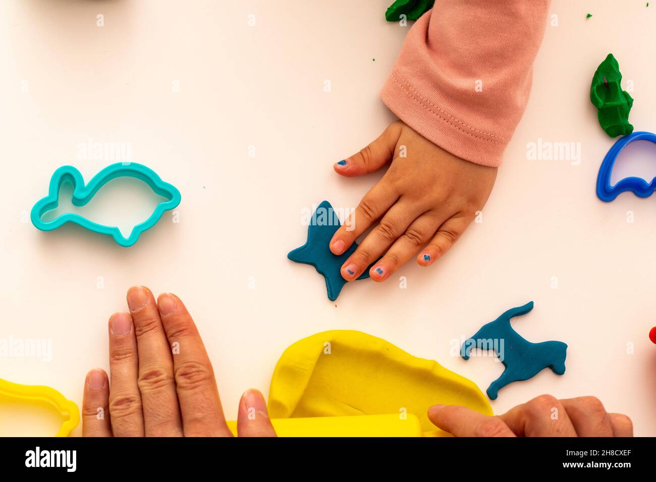 Fille jouant de la pâte avec son père. Fille père jouant au jeu sur fond blanc.Faire différentes formes avec de la pâte.Gros plan.Fête des pères Banque D'Images