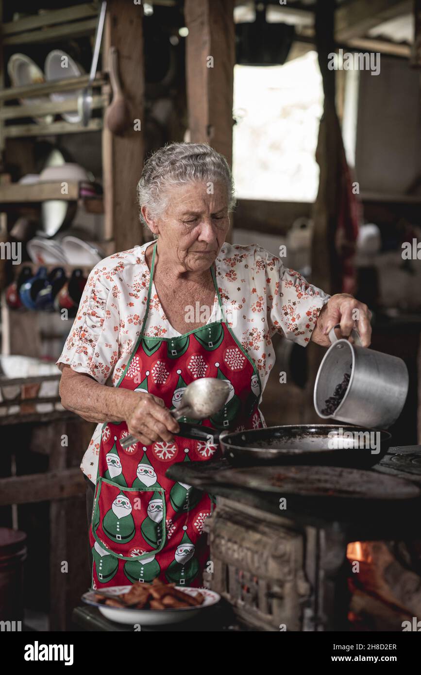 Prise de vue verticale d'une vieille femme hispanique qui cuisine des tortillas de maïs à Tilaran, Guanacaste, Costa Rica Banque D'Images