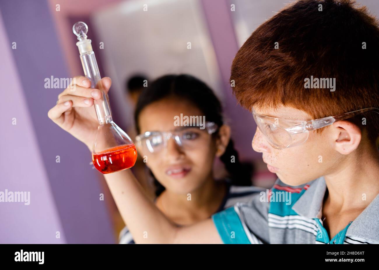 Gros plan sur le mélange concentré de produits chimiques pour enfants dans le ballon de Florence tout en faisant l'expérience au laboratoire de chimie - concept de l'éducation, de la connaissance Banque D'Images