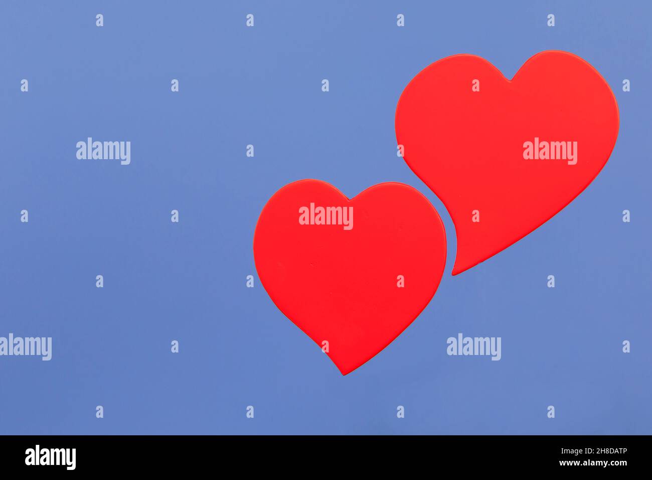 Deux coeurs rouges épais sur fond bleu Banque D'Images
