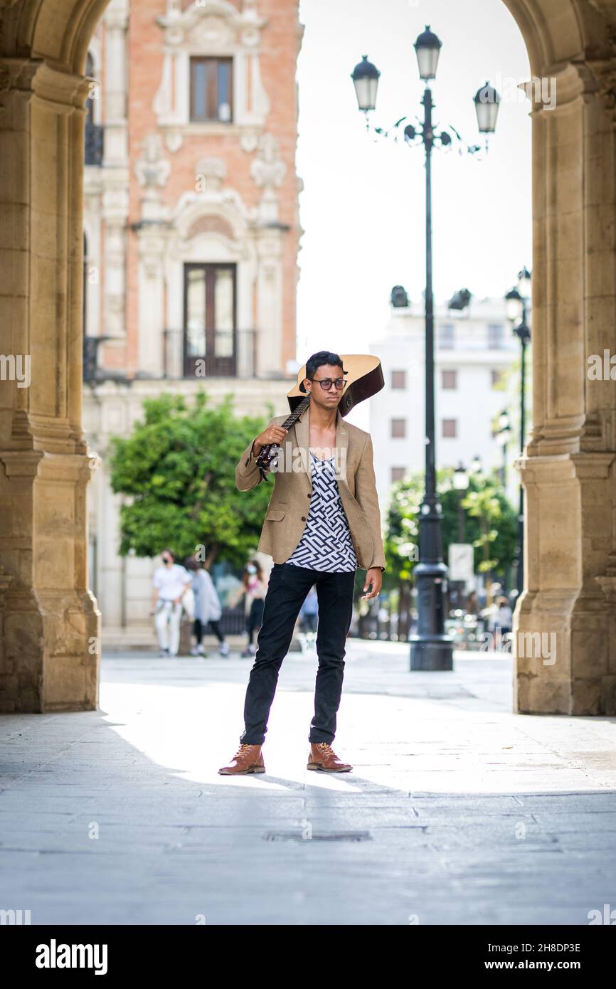 Latino Street musicien posant avec une guitare sur son épaule dans la rue Banque D'Images