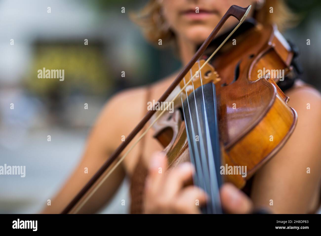 Détail d'un violoniste à cheveux rouges non reconnaissable jouant du violon dans la rue Banque D'Images