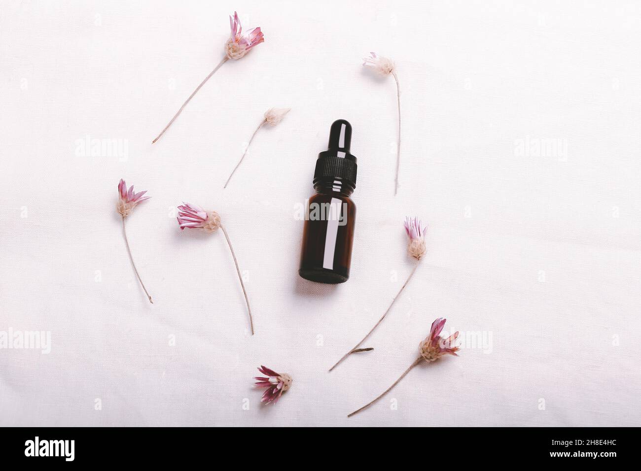 Laboratoire cosmétique abstrait.Bouteilles de verre ambré foncé sur fond blanc de lin biologique.Cosmétiques naturels pour les soins, homéopathie.Modèle plat, haut Banque D'Images