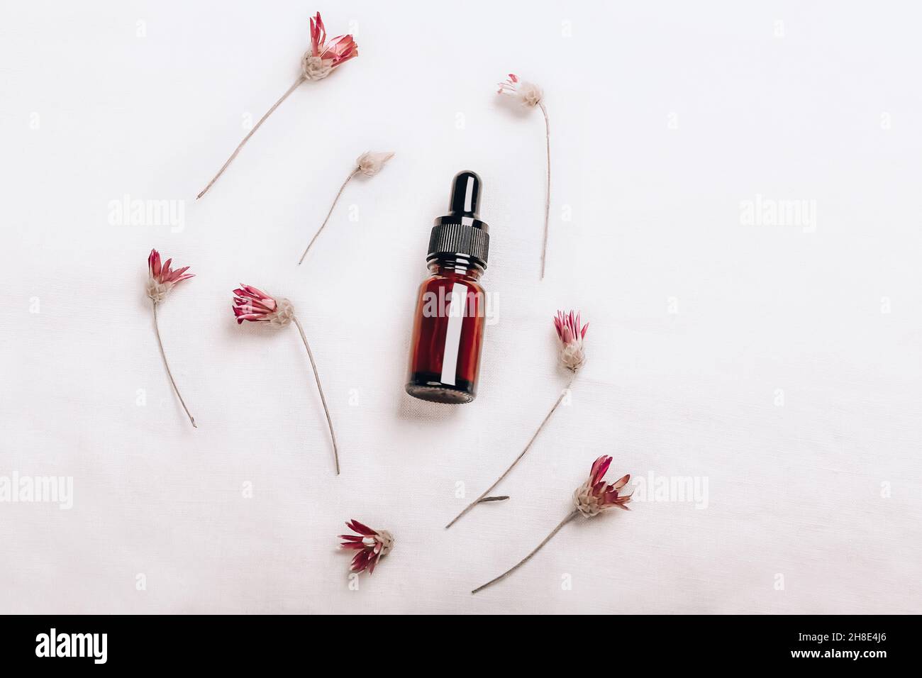 Laboratoire cosmétique abstrait.Bouteilles de verre ambré foncé sur fond blanc de lin biologique.Cosmétiques naturels pour les soins, homéopathie.Modèle plat, haut Banque D'Images