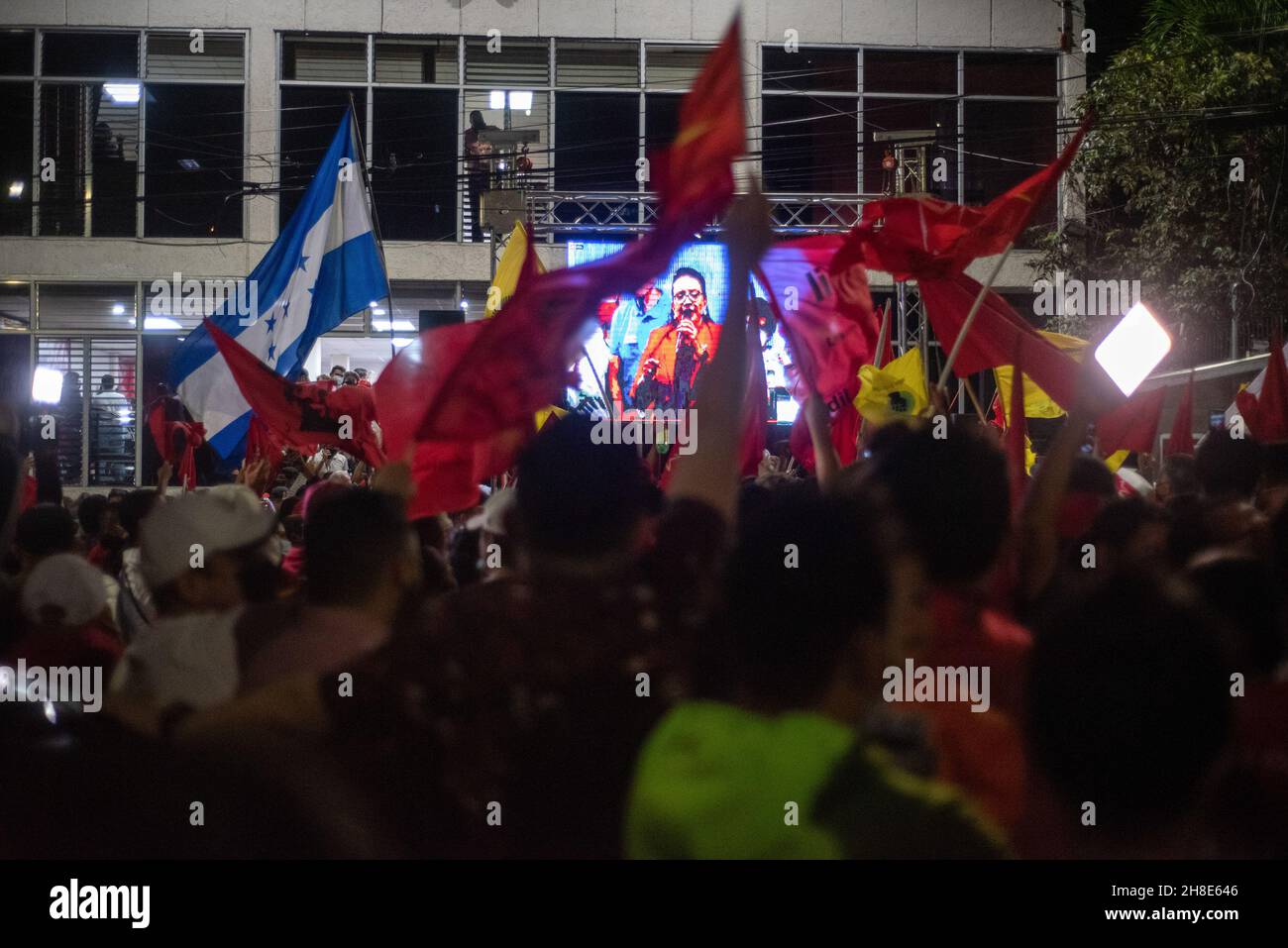Les partisans brandient les drapeaux tout en regardant Xiomara Castro prononcer un discours après les résultats préliminaires lors de l'élection présidentielle.Le 28 novembre, le Honduras a tenu ses élections présidentielles, après 12 ans de parti national qui contrôle l'opposition, le Parti libre et Xiomara Castro ont une chance de reprendre le pouvoir.Castro a prononcé un discours après que les premiers résultats des votes l'ont montré à la tête de 20 pour cent.Les partisans du Parti libre l'ont célébré toute la nuit comme une victoire, bien qu'aucune décision sur le vainqueur n'ait encore été officielle.(Photo de Seth Sidney Berry/SOPA Images/Sipa USA) Banque D'Images