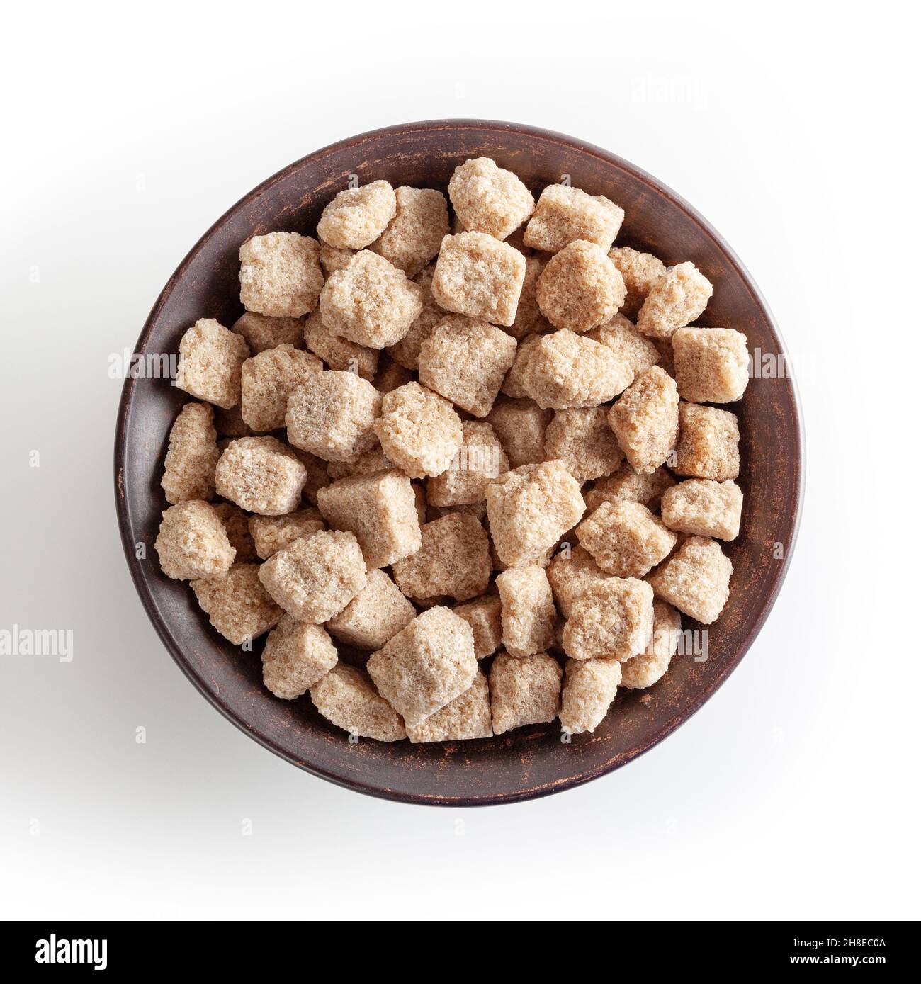 Cubes de sucre de canne à sourcils dans un bol en céramique isolé sur fond blanc avec passe-cheveux Banque D'Images