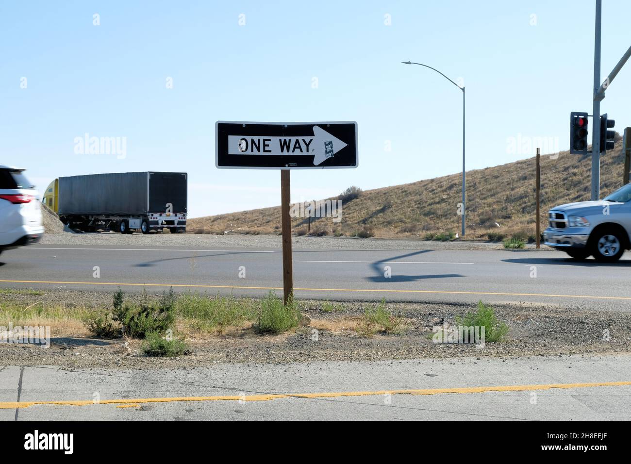 Un panneau de signalisation à flèche à sens unique indiquant les conducteurs vers la direction de circulation du véhicule près d'une bretelle d'accès d'autoroute dans le centre de la Californie, aux États-Unis. Banque D'Images