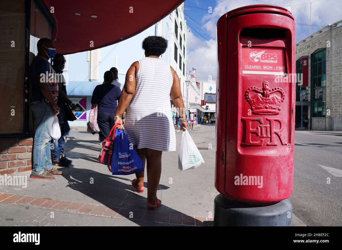 Une femme passe devant une boîte postale qui porte encore le cypher royal de la reine Elizabeth II à Bridgetown, à la Barbade.À minuit, le 29 novembre 2021, la Barbade deviendra officiellement une république à Bridgetown, à la Barbade.Date de la photo: Lundi 29 novembre 2021. Banque D'Images