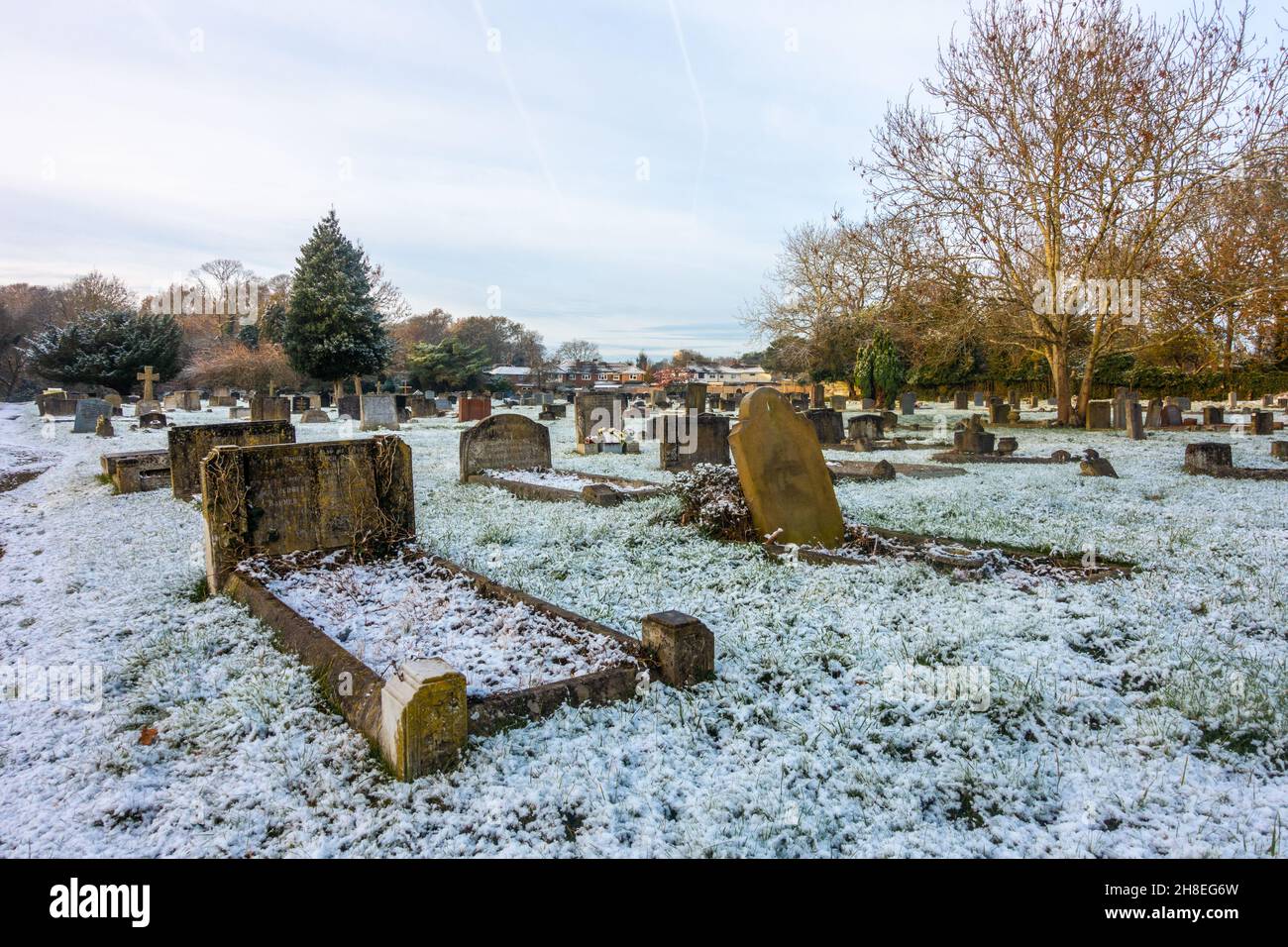 Vue sur le cimetière de l'église St Michael's à Tilehurst Reading en hiver avec une couverture de neige légère. Banque D'Images