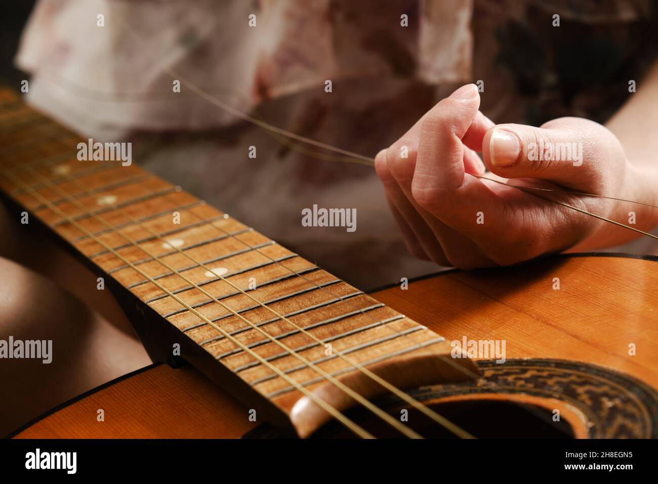 Cordes de guitare brisées avec mains de femmes, réparation de guitare Banque D'Images