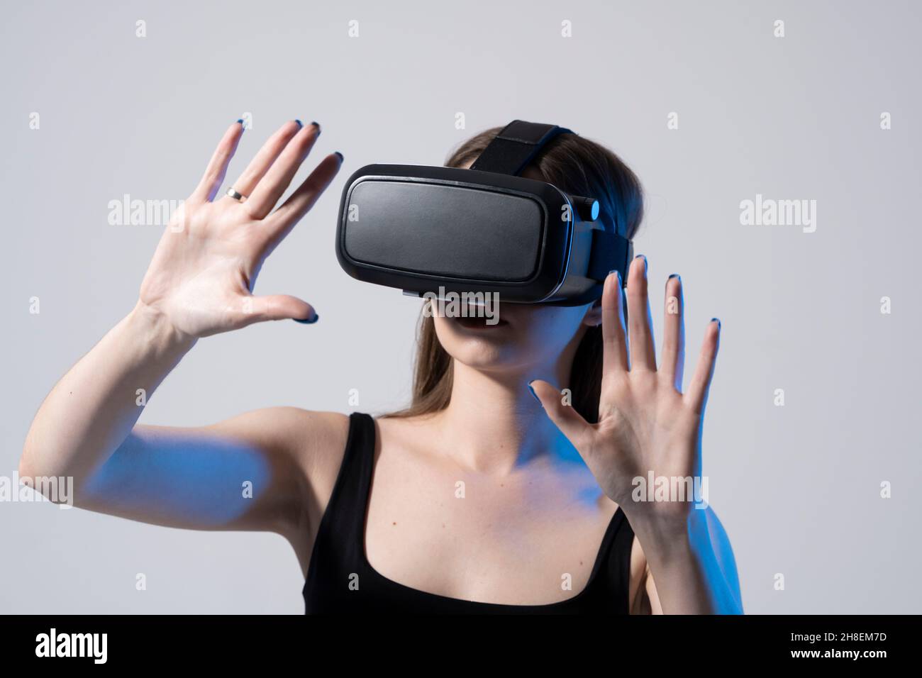 Architecte moderne, designer femme portant des lunettes VR et interagit avec métaverse à l'aide de gestes de glissement et d'étirement.Concept technologique futur. Banque D'Images