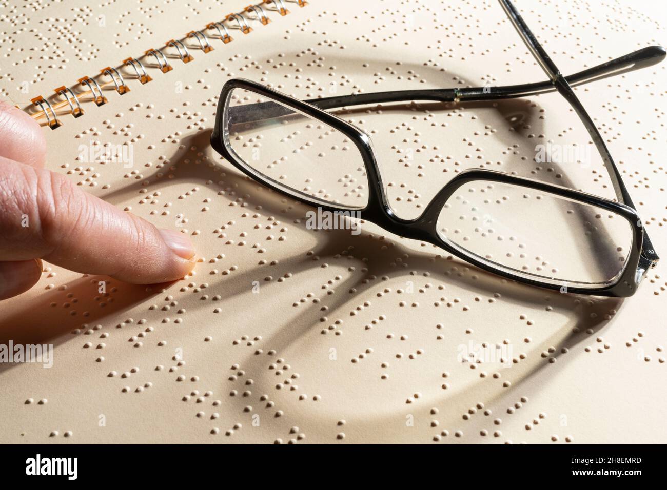 Une paire de lunettes sur une page écrite en braille, le système de lecture tactile en relief pour les aveugles Banque D'Images