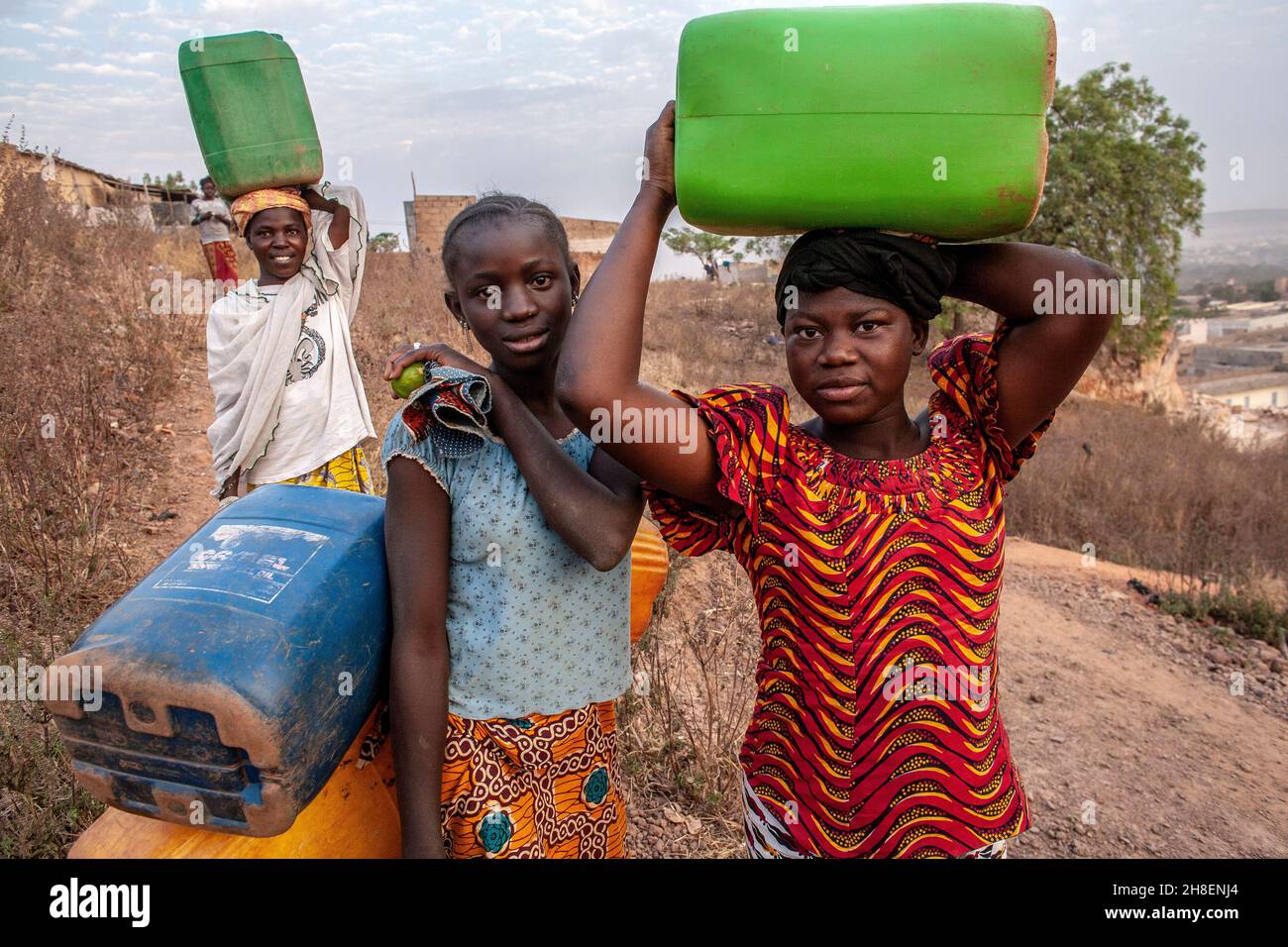 Des filles africaines transportant de l'eau douce dans un village à l'extérieur de Bamako, au Mali. Banque D'Images