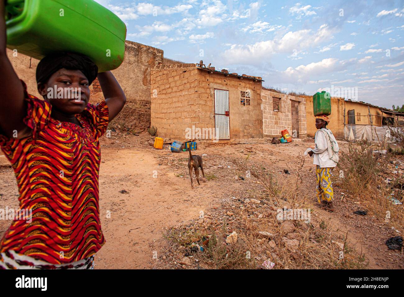 Des filles africaines transportant de l'eau douce dans un village à l'extérieur de Bamako, au Mali. Banque D'Images