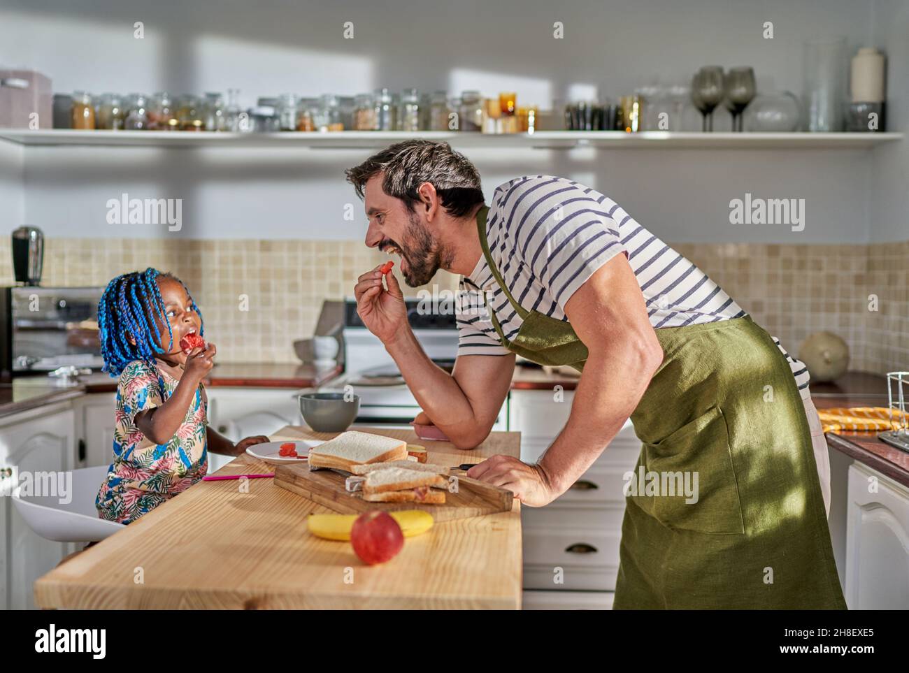 Père et fille mangeant à l'île de cuisine Banque D'Images