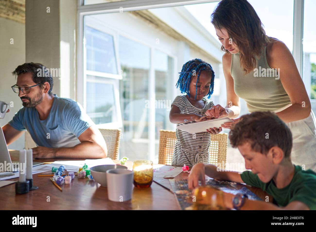 Famille travaillant et jouant à la table de salle à manger Banque D'Images