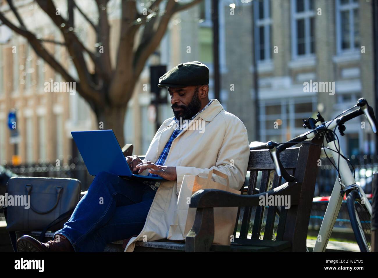 Businessman working at laptop in city park Banque D'Images