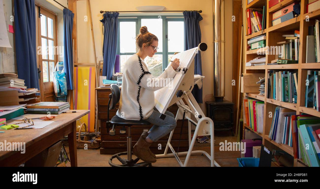 Femme architecte travaillant à la table à dessin dans le bureau à domicile Banque D'Images