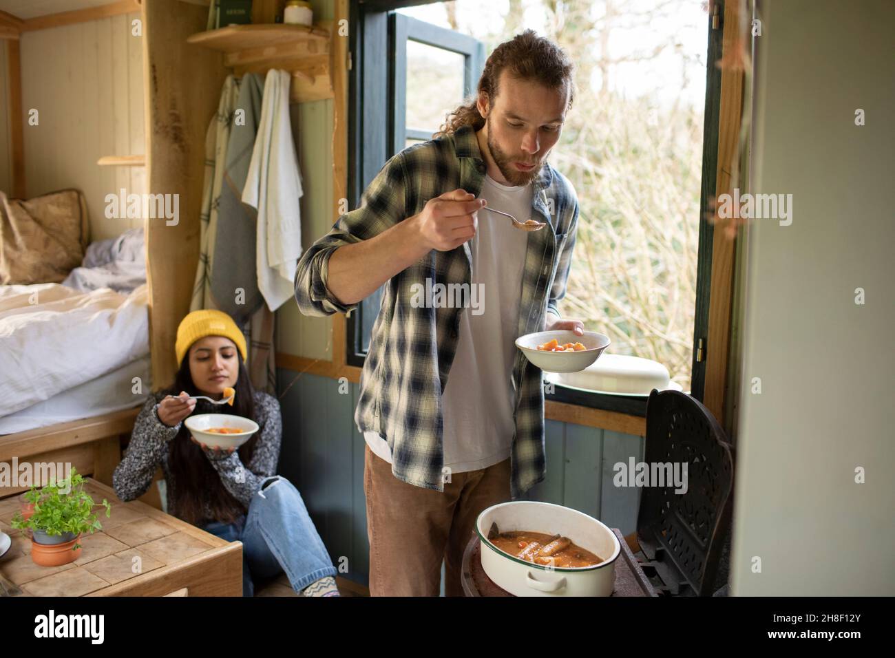 Un jeune couple qui cuisine dans une petite cabine de location Banque D'Images