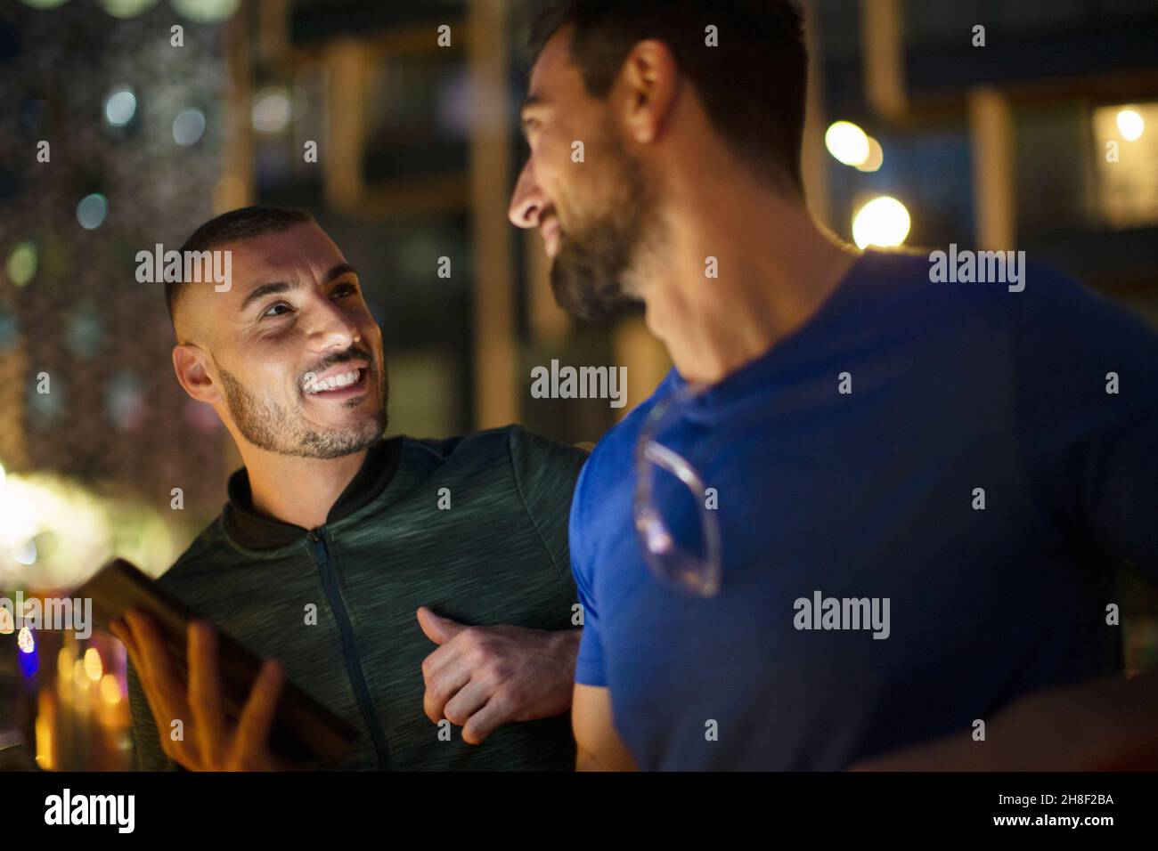 Hommes heureux amis masculins parlant la nuit Banque D'Images Hommes heureux amis masculins parlant la nuit Banque D'Images