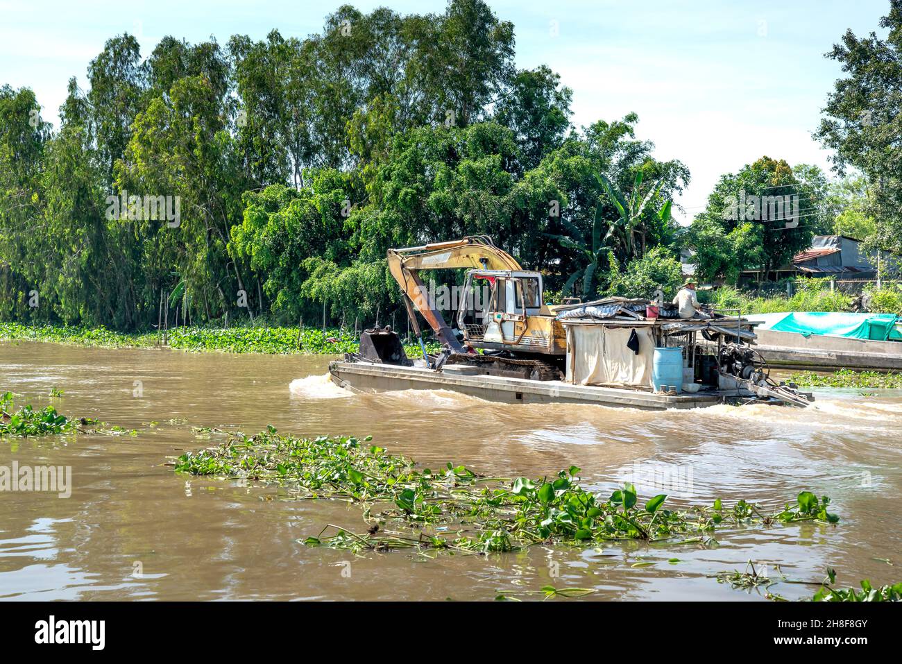 District de MOC Hoa, province de Tay Ninh, Vietnam - 23 novembre 2021 : un camion de pelle hydraulique se déplace par barge sur une rivière dans la province de Tay Ninh, Vietnam Banque D'Images