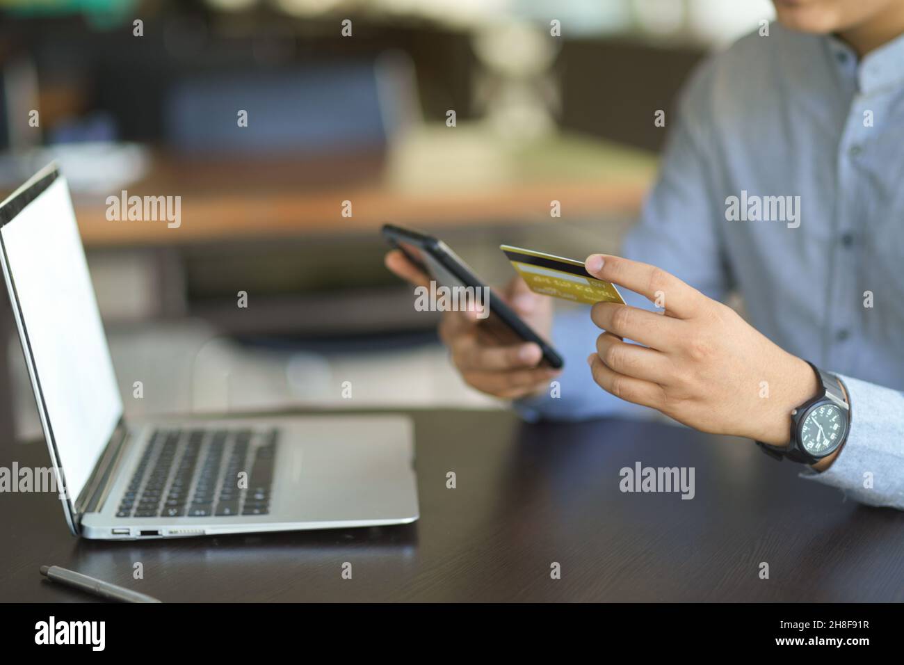 Image rognée d'Un homme ou d'un homme d'affaires tenant une carte de crédit et un smartphone à son bureau. internet Online Banking concept. Banque D'Images