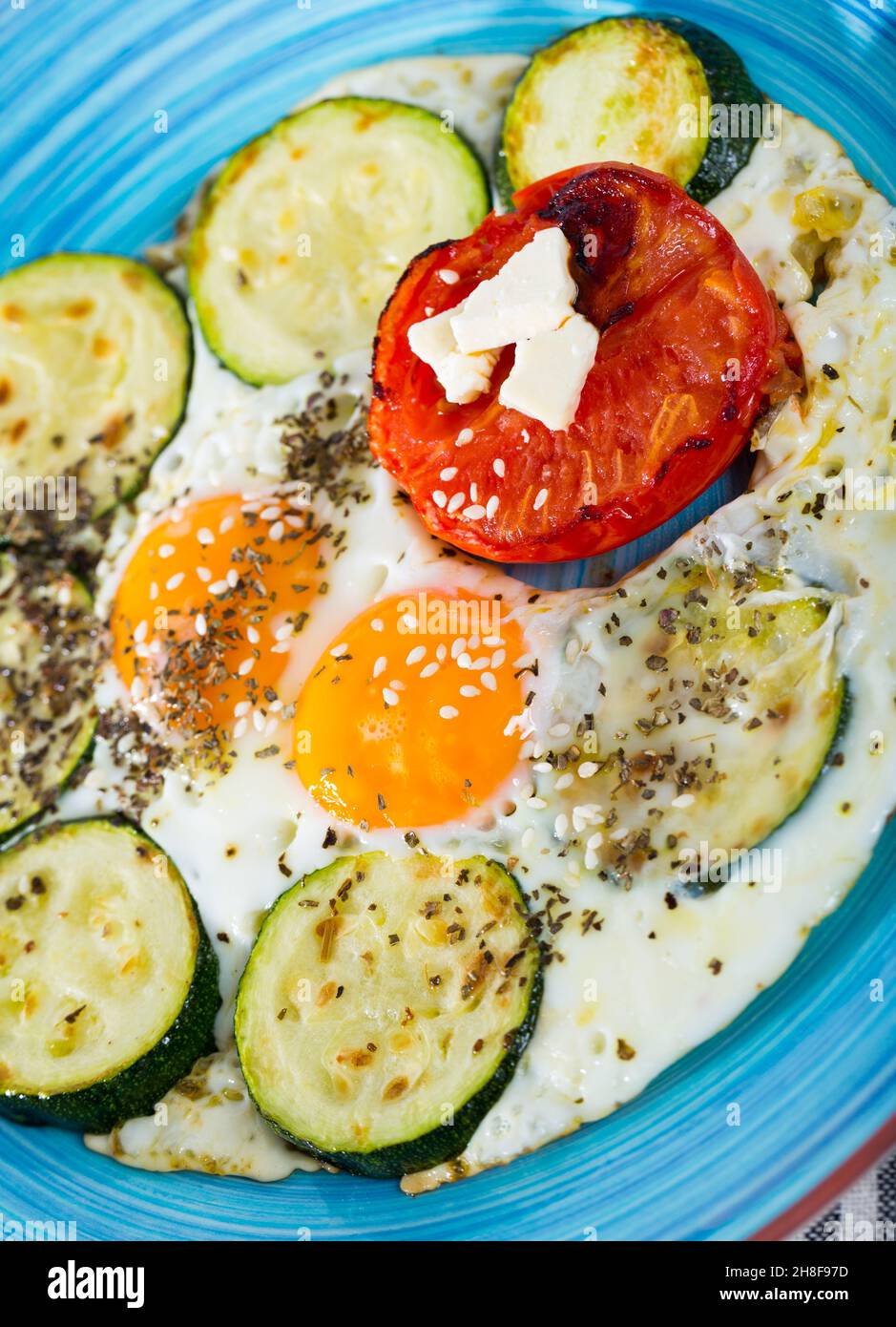 Œufs frits avec courgettes et tomates Banque D'Images