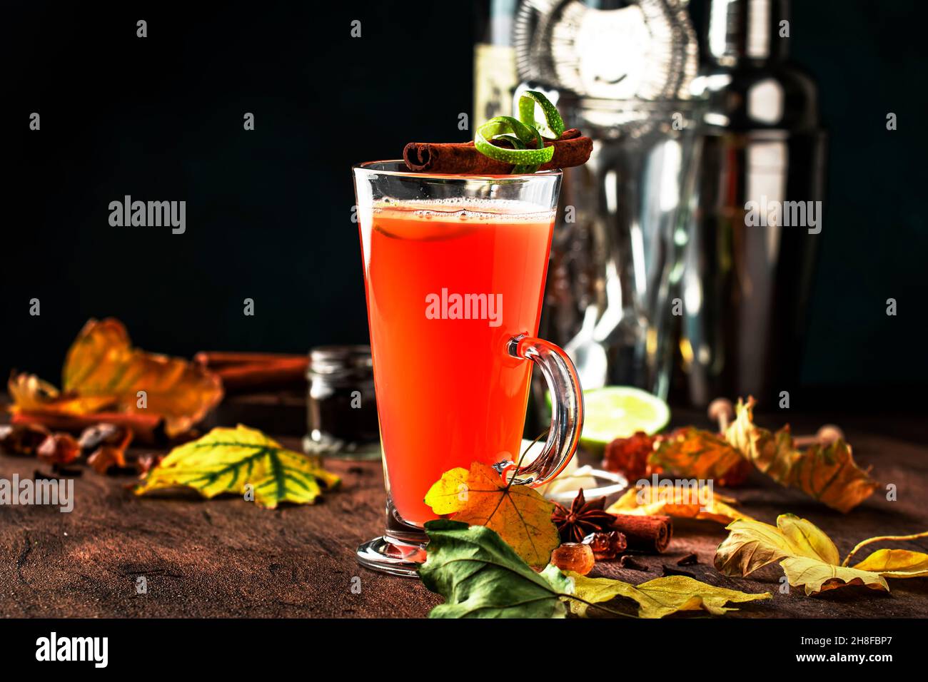 Rhum au beurre chaud, cocktail chaud d'hiver avec jus de pomme, rhum foncé, miel, cannelle en verre sur fond de bois Banque D'Images