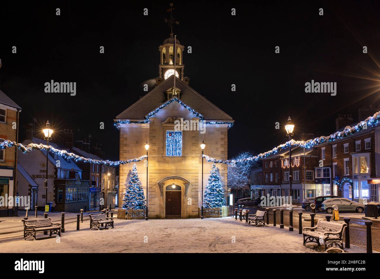 Arbres de Noël et lumières à l'extérieur de l'hôtel de ville de brackley dans la neige du soir.Brackley, Northamptonshire, Angleterre Banque D'Images