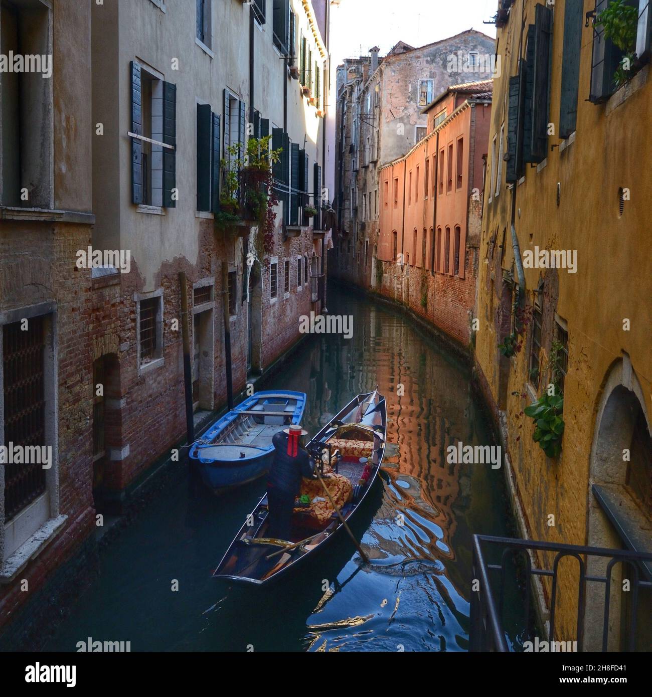 Un canal étroit typique à Venise, Italie.Un aviron gondolier Banque D'Images