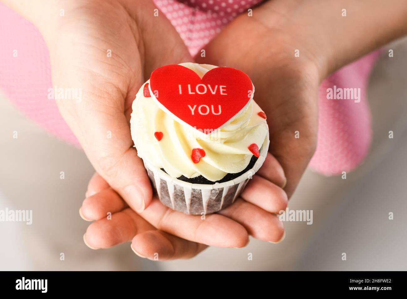 Fille tenant un gâteau en forme de coeur avec l'inscription Je t'aime.Cupcake en forme de coeur, gros plan Banque D'Images