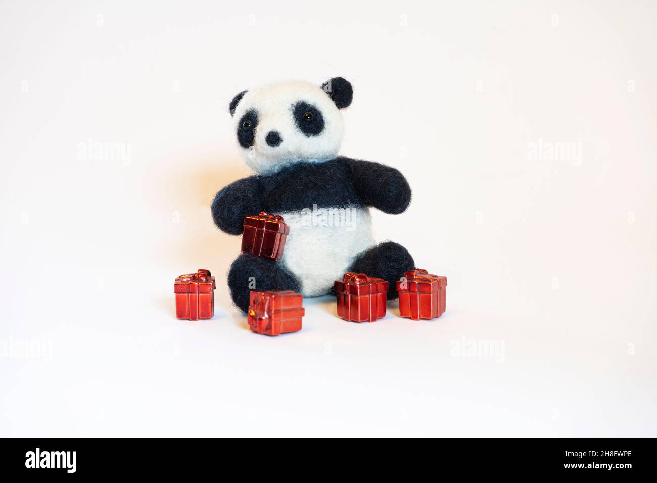 Aiguille feutrage panda assis avec des cadeaux avec fond blanc. Banque D'Images