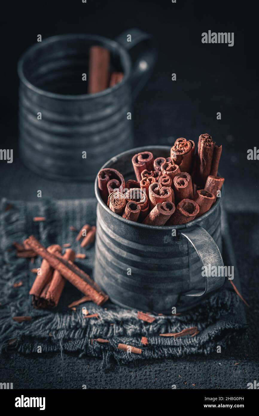 Bâtonnets de cannelle aromatiques dans une tasse sombre.Arôme épicé et sucré.L'épice de base dans le monde. Banque D'Images