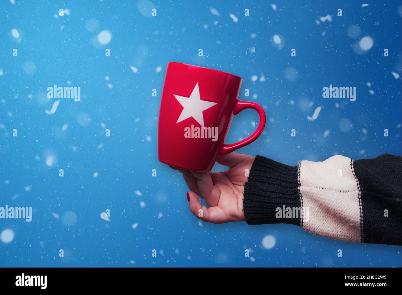 Mug de Noël rouge avec fond bleu enneigé.Design de Noël. Banque D'Images
