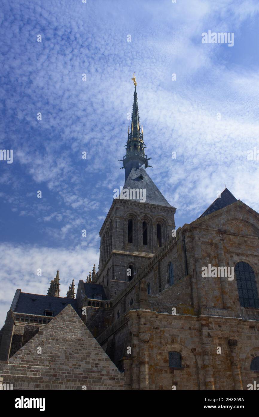 spire de l'abbaye du Mont Saint Michel, Normandie, France.Le ciel est bleu et partiellement obscurci. Banque D'Images