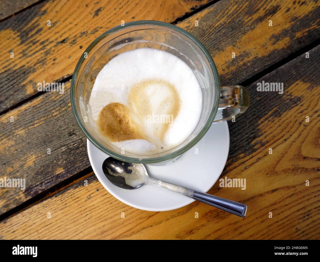 Latte café en forme de coeur sur une ancienne table en bois, vue de dessus Banque D'Images