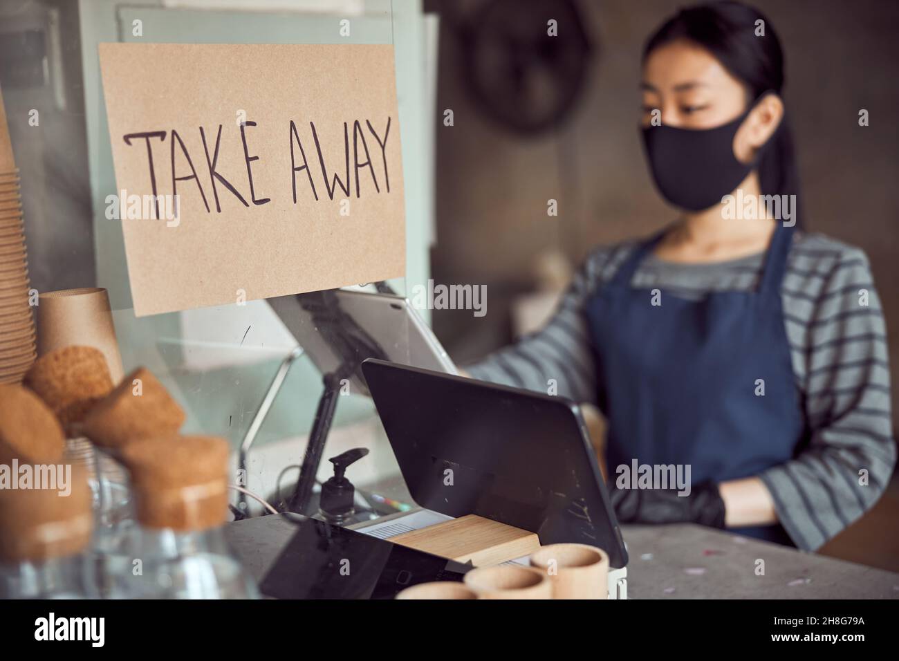 Employeur asiatique travaillant avec des commandes à emporter à l'intérieur Banque D'Images