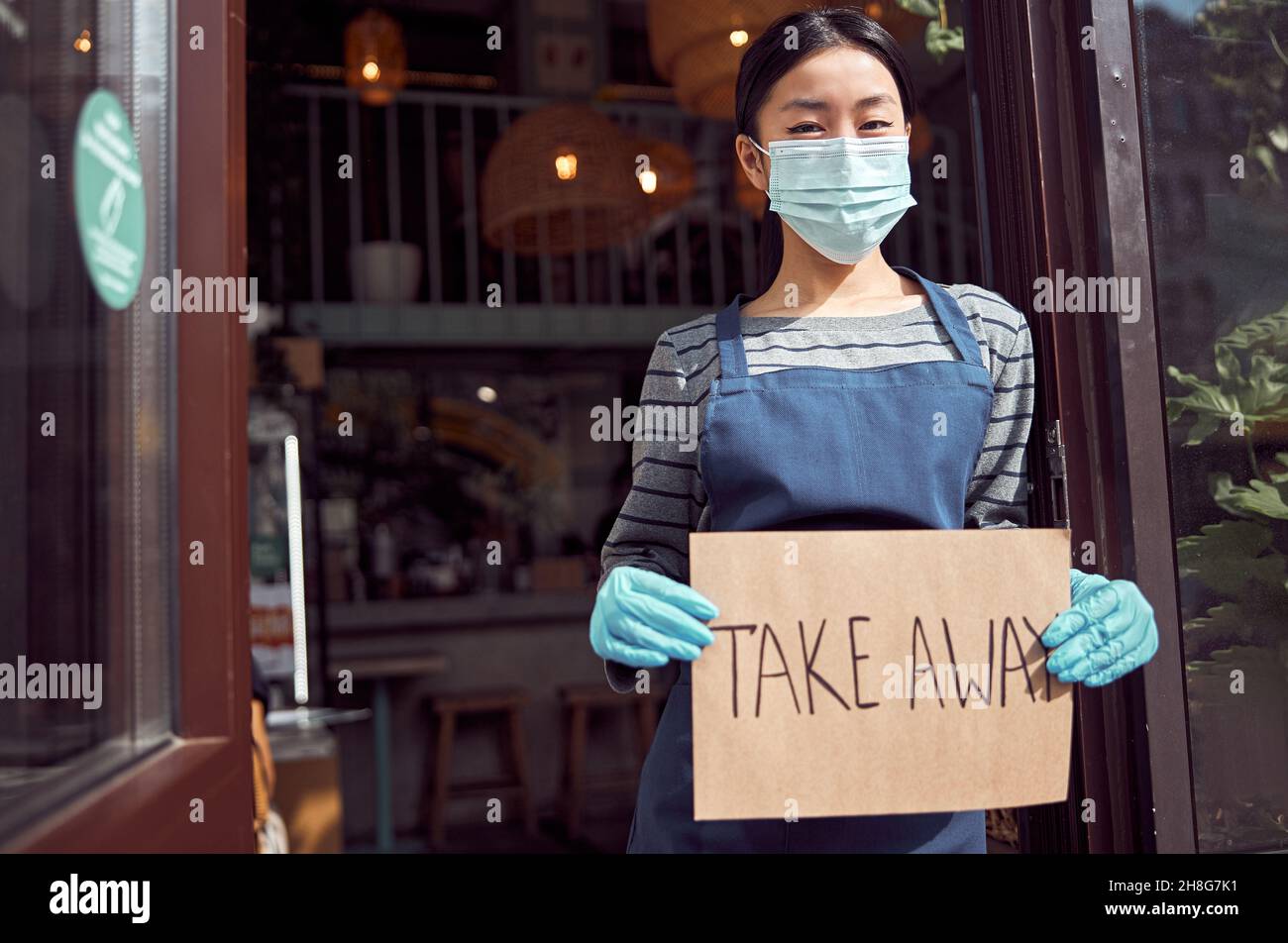 Femme serveuse tenant une affiche à emporter avant le café Banque D'Images