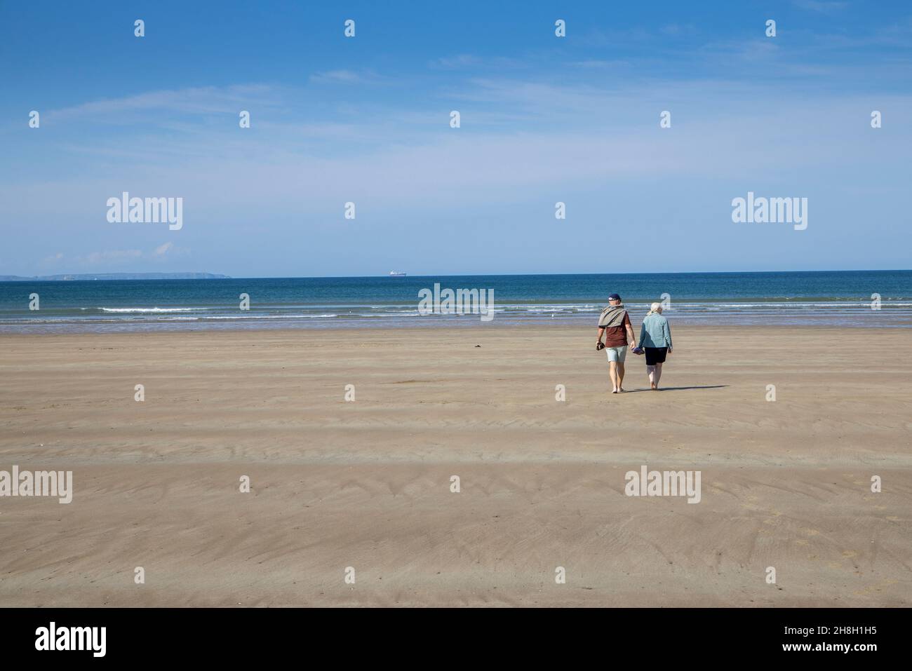 Couple marchant sur la plage à Newgale, Pembrokeshire, pays de Galles, Royaume-Uni Banque D'Images