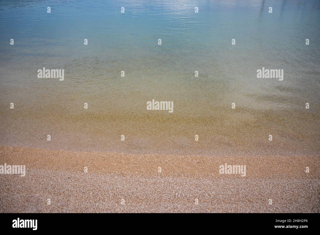 Ondulations sur la surface du fond de mer de sable, eau de mer bleue claire et calme, poissons dans l'eau, texture de la nature Banque D'Images