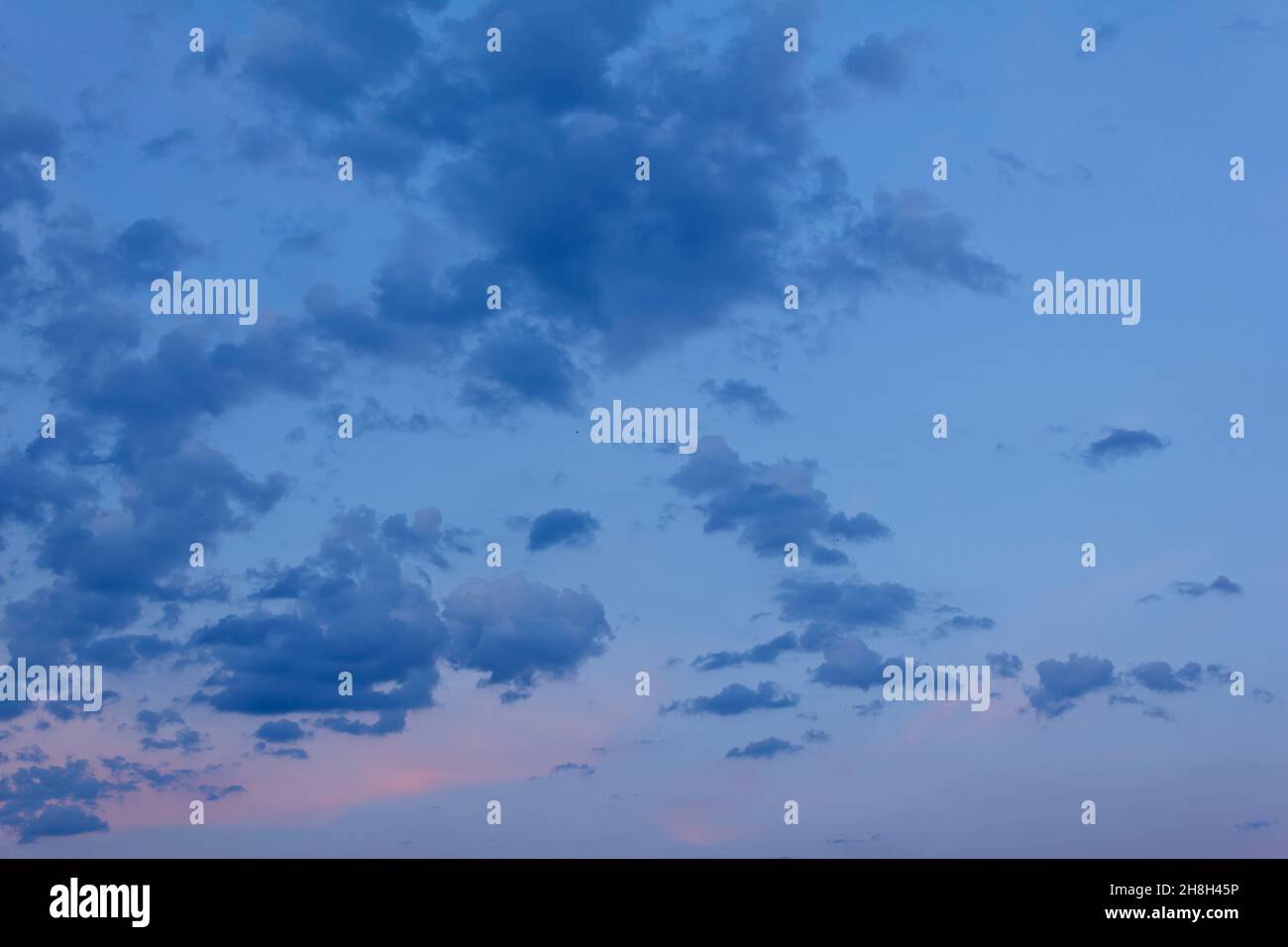 Nuages bleu foncé après le coucher du soleil avec les derniers rayons de soleil orange rouge, texture d'arrière-plan douce et nuageux. Banque D'Images