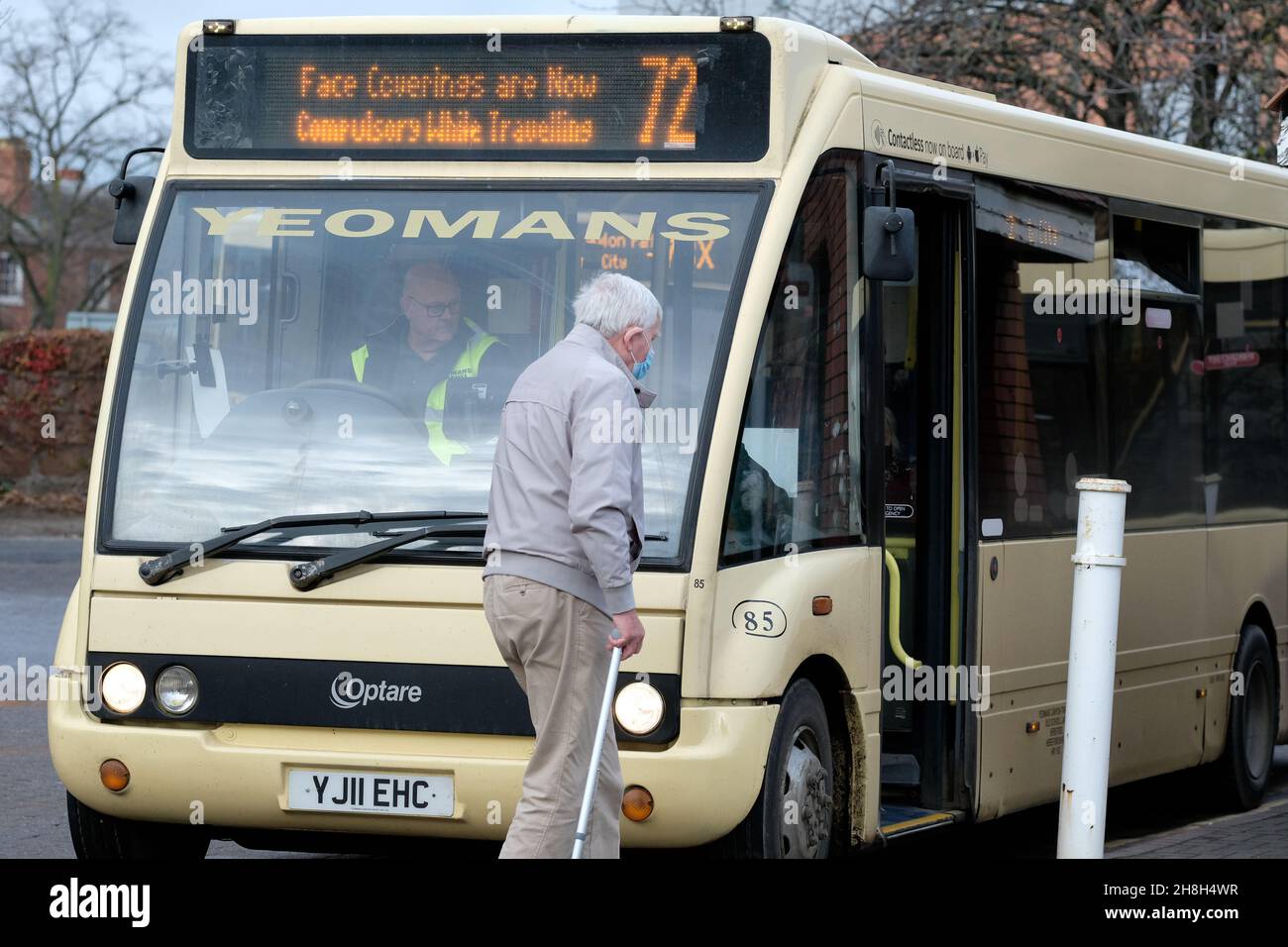 Hereford UK - un homme âgé avec un masque de visage et un bâton de marche sur le point de monter à bord d'un bus local avec un panneau obligatoire de masque de visage - 30 novembre 2021 Royaume-Uni Banque D'Images