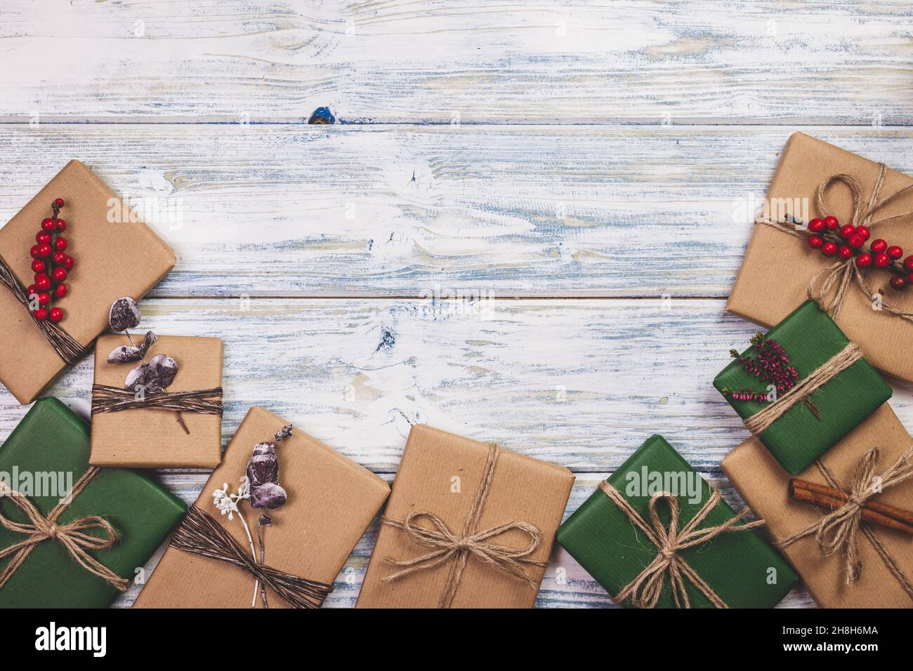 Cadeau de Noël enveloppé avec décoration sur table en bois blanc.Pose à plat de boîtes-cadeaux en papier d'emballage kraft vert et brun Banque D'Images