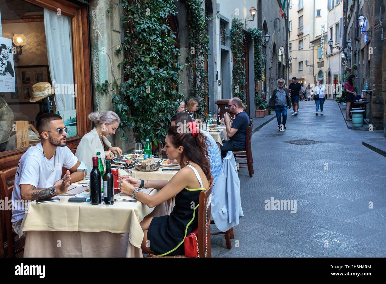 Les personnes peuvent se asseoir à des tables à l'extérieur d'un restaurant pour le déjeuner.Florence.Italie. Banque D'Images