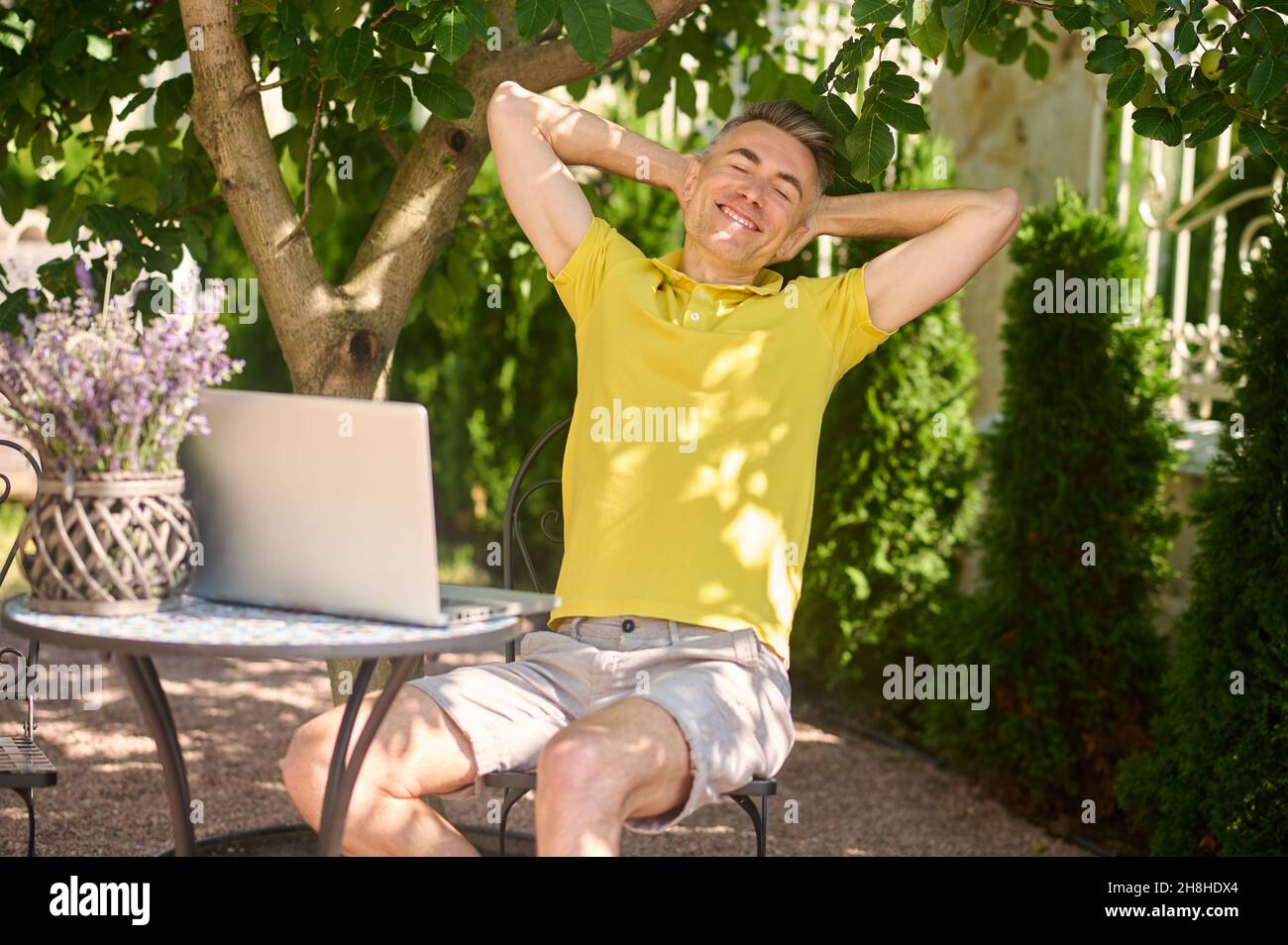 Un homme assis à l'ordinateur portable et se sentant fatigué après le travail Banque D'Images