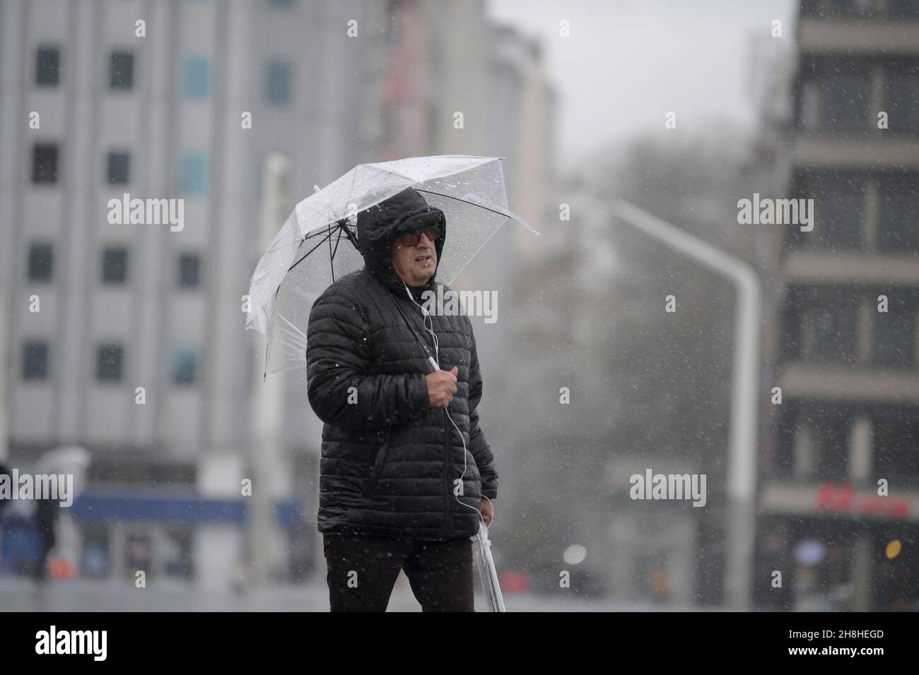 (211130) -- ISTANBUL, 30 novembre 2021 (Xinhua) -- Un homme tenant un parapluie marche sous la pluie sur la place Taksim à Istanbul, Turquie, 30 novembre 2021.De fortes tempêtes de vent ont tué au moins six personnes et en ont blessé plus de 50 autres dans la région nord-ouest de la Turquie depuis lundi, selon les médias locaux.(Xinhua/Sadat) Banque D'Images