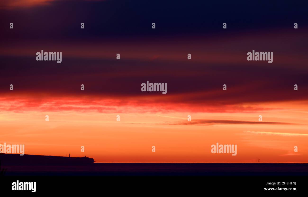 Lever de soleil à l'est depuis Mumbles Head, au-dessus de la mer jusqu'à l'horizon lointain et les nuages colorés rouge et orange par le soleil tôt le matin. Banque D'Images