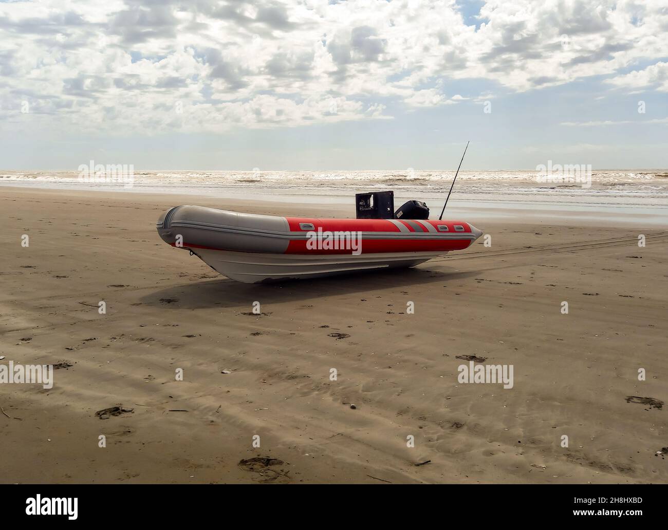 Bateau gonflable à coque rigide avec moteur hors-bord sur la rive battue par les vagues. Utilisé pour pêcher en mer Banque D'Images