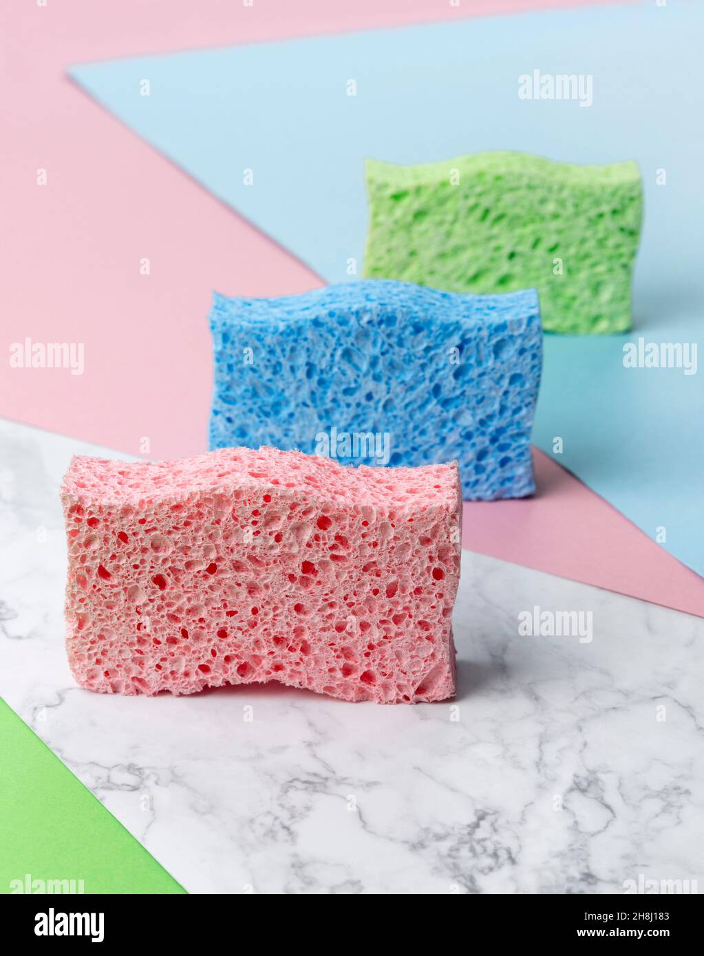 Disposition créative avec éponges pour le lavage de la vaisselle sur fond multicolore Banque D'Images